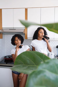 Two black women drinking coca cola in their kitchen