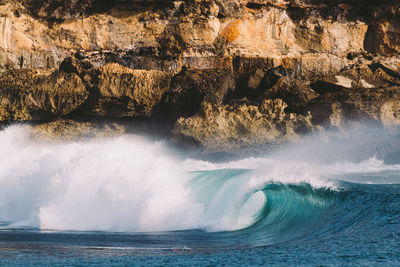 Scenic view of a wave against rock