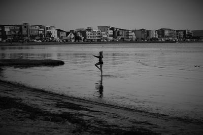 Man on beach against buildings in city