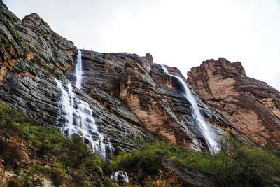 Low angle view of waterfall against sky