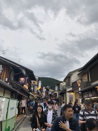 People on street in city against sky