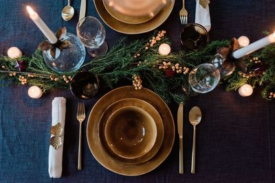 Sky view of a modern dinner table setting with candles and greenery