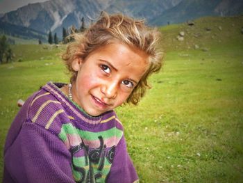 Smiling girl wearing sweater looking away on field