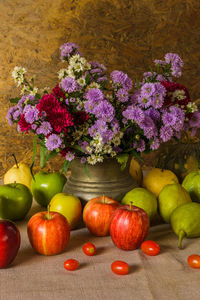 Still life with apples and pears are placed with beautiful flower vases.