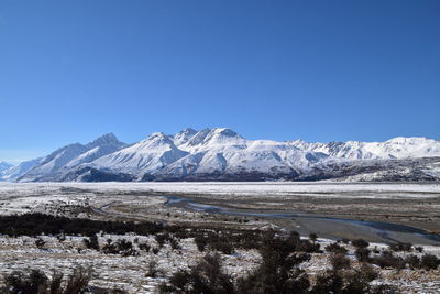 Scenic view of snowcapped mountains against clear blue sky