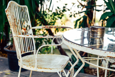 Close-up of empty chairs and table at sidewalk cafe