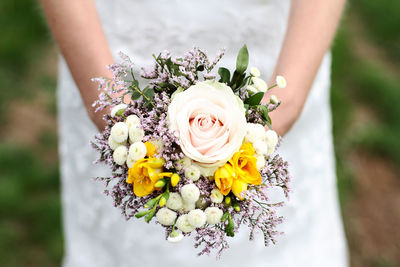 Midsection of woman holding bouquet