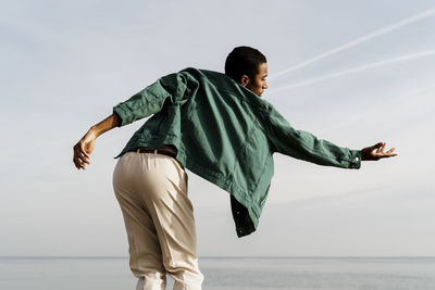 Side view of boy in sea against sky