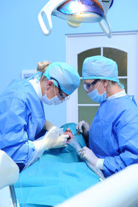 Doctors performing dental implantation in operating room