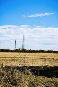 Electricity pylon on field against sky