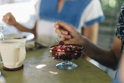 Close-up of hand holding ice cream in bowl