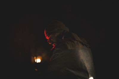 Silhouette man against illuminated light painting at night