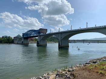 Arch bridge over river against sky