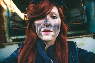 Portrait of young woman with charcoal stain on face