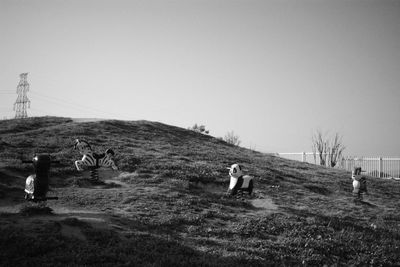 Horses on field against clear sky