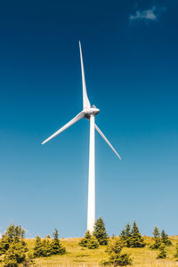 Low angle view of windmill on field against clear sky