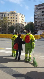 Rear view of people walking on road