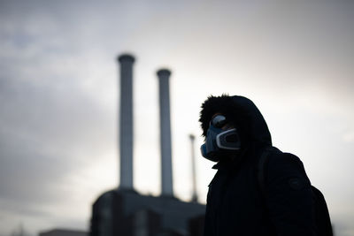 Low angle view of person with mask standing against sky after worldwide  epidemic of coronavirus in 