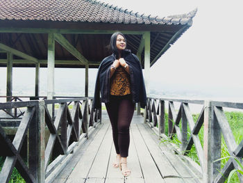 Full length of woman standing on footbridge