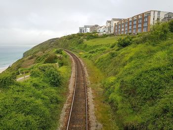 Panoramic shot of railroad tracks by sea against sky