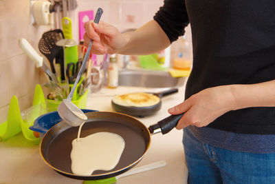 Midsection of woman having food at home