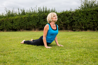 Full length of woman with arms raised on field