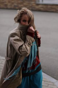 Portrait of woman in warm clothing walking on sidewalk