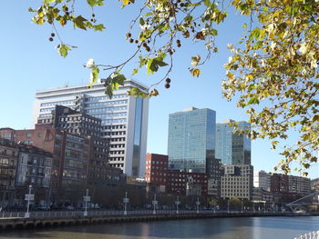 Low angle view of buildings by river against sky