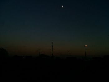 Silhouette of trees against sky at night