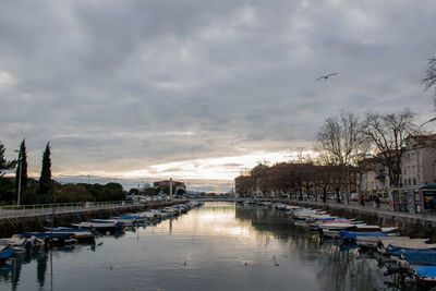 Boats moored in river with buildings in background