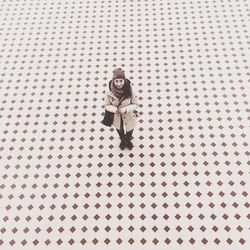 High angle portrait of woman standing on tiled floor