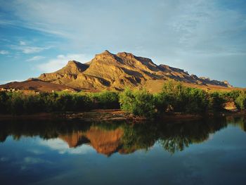 Scenic view of lake by mountains against sky