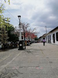 View of city street against cloudy sky