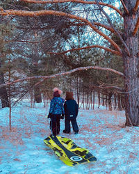 Rear view of people walking on snow covered land