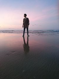 Full length of man standing on beach during sunset