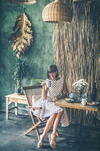 Woman sitting on chair with table