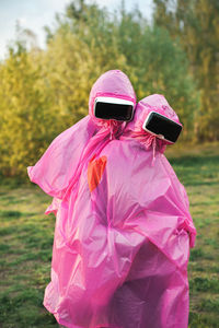 Portrait couple wearing virtual reality simulator on grassy field