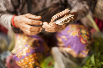 Midsection of woman holding paper currency