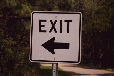 Close-up of road sign against trees