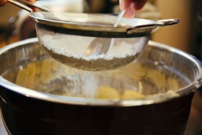 Close-up of hand pouring water in bowl