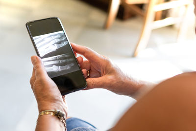 Midsection of man using mobile phone