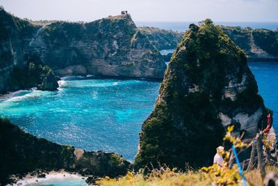 Rock formation on sea shore against sky