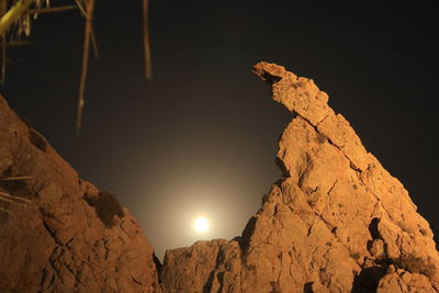 Low angle view of rocks against sky at night