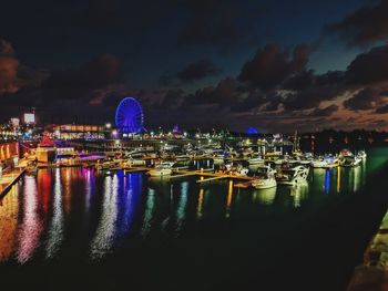 Boats moored in harbor at night