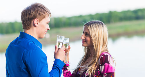 Side view portrait of a smiling young man drinking woman