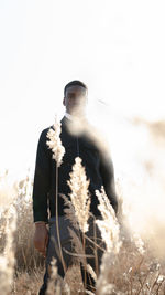 Low section of person standing on field against sky