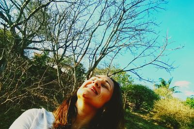 Portrait of young woman against tree