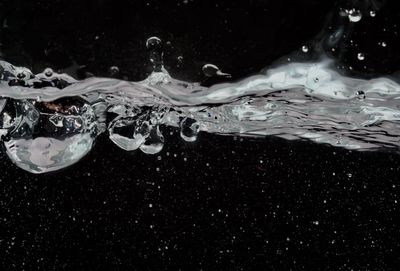 Close-up of water splashing in sea against sky