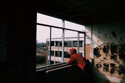 Man standing by window in abandoned building