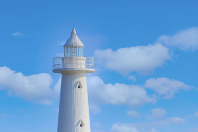 Lighthouse by sea against sky